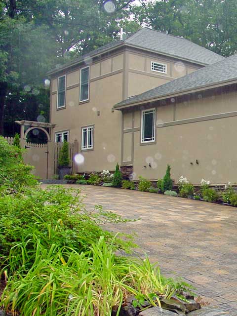 multi-colored and mixed sized paver driveway and tudor home