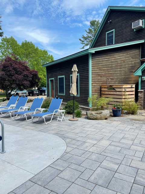 a pattern of pavers extends the cement pool coping