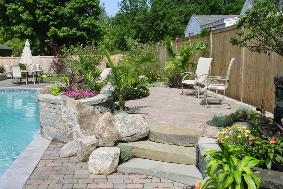 stone work and design by gogan landscaping takes pool deck above and beyond