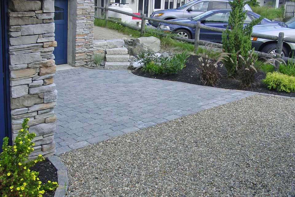 full frontal view of home with stone driveway